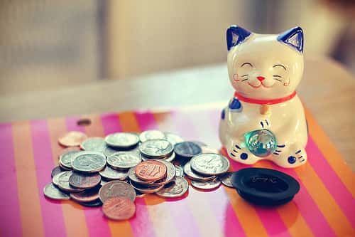 japanese porcelain cat with coins on table