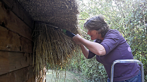 woman thatching a roof